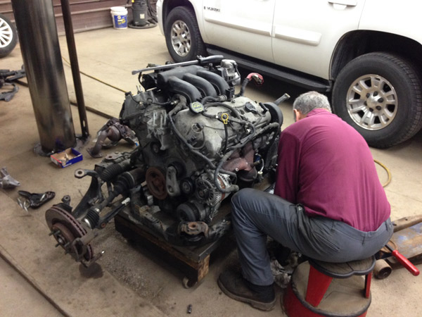Engine beside a vehicle during shop work